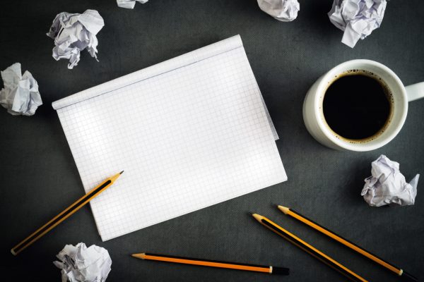 Creative Writing Concept With Pencils, Coffee Cup, Notepad and Crumpled Paper on Table, Top View.